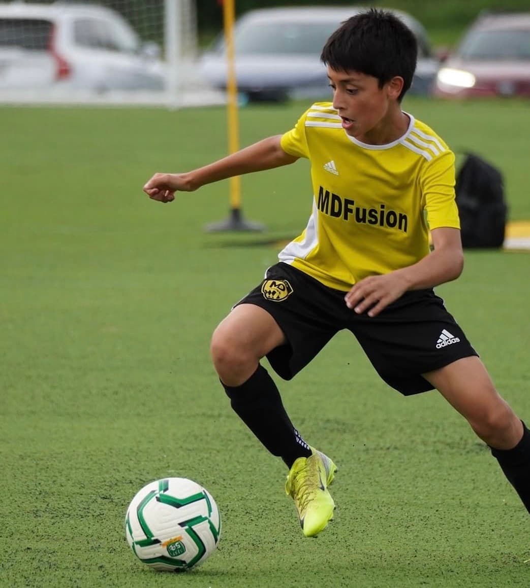 An MD Fusion player driving toward the ball during a training session
