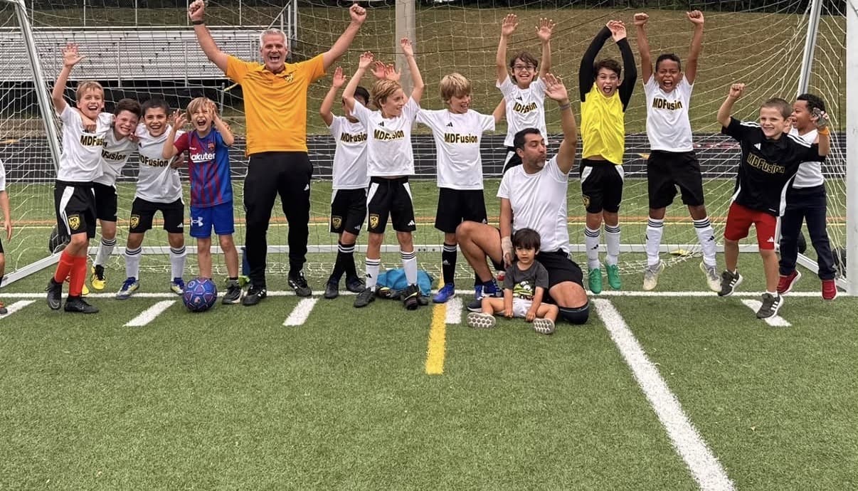 MD Fusion players and coaches celebrating together on the field